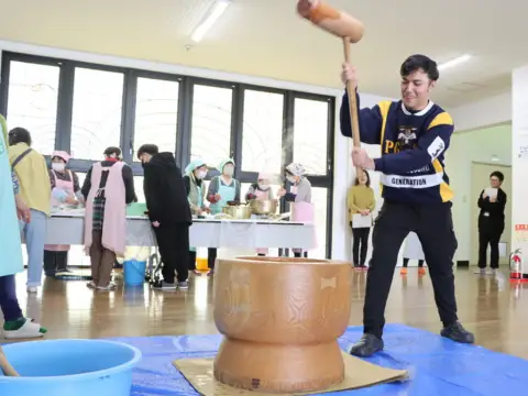 Siswa Osaki Japanese Language School melakukan mochitsuki dengan palu kayu