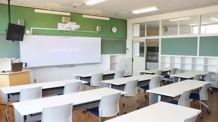 Ruang kelas Osaki Japanese Language School dengan papan tulis hijau dan meja belajar